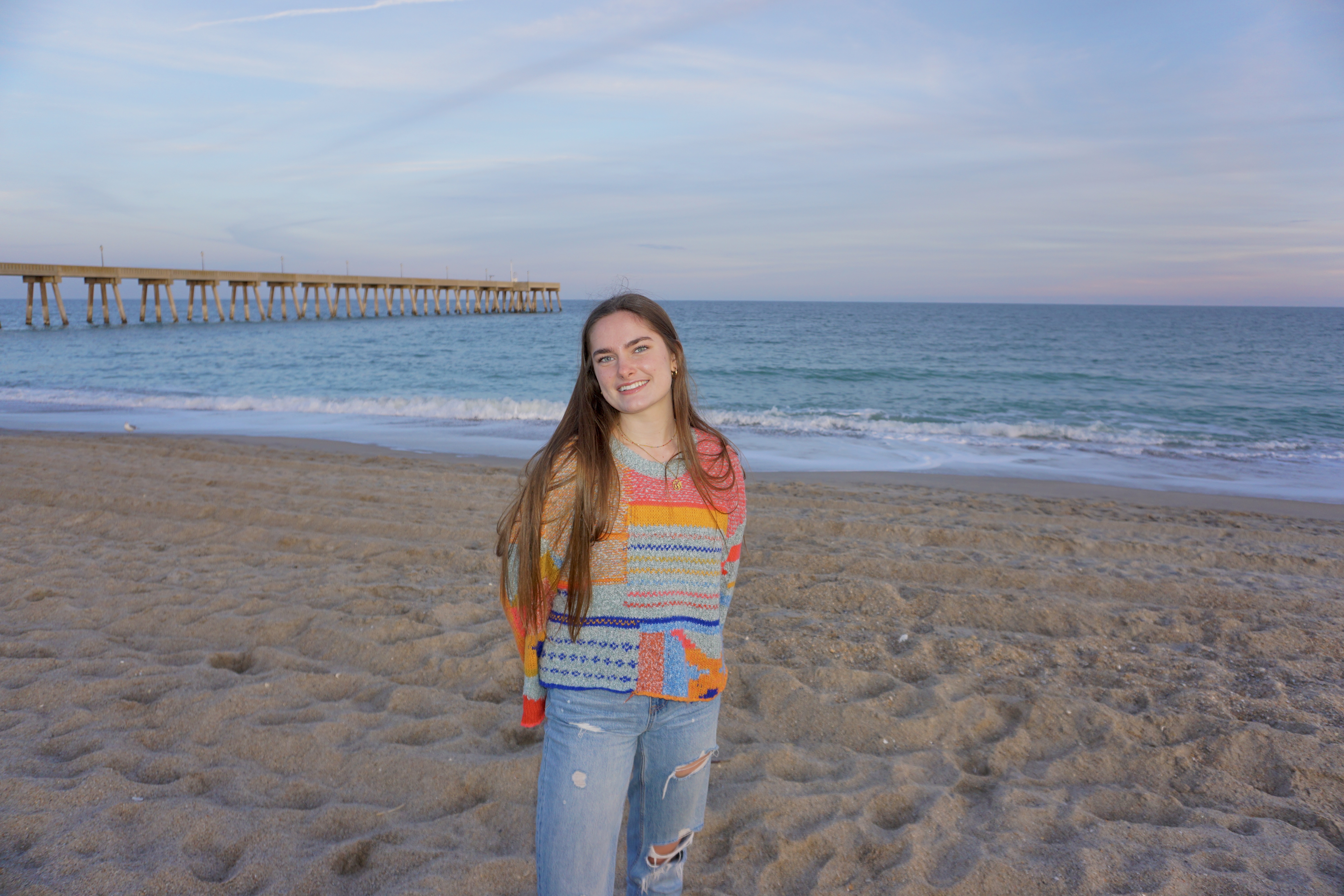 Audrey Merna on a beach in a colorful shirt.
